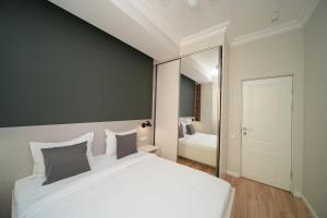 埃里温Modern apartments in the heart of Yerevan by Sweet Home的卧室里有一张白色的大床和一面镜子