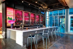 ローリーにあるAloft Raleigh Durham Airport Brier Creekのレストラン内にスツールが並んだバー