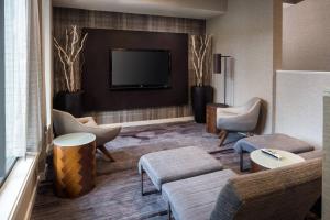 a hotel lobby with a tv and chairs and a couch at Courtyard San Francisco Larkspur Landing/Marin County in Larkspur