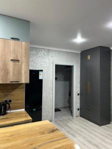 a kitchen with black cabinets and a black refrigerator at VIP студия вместе с XBOX in Kostanay