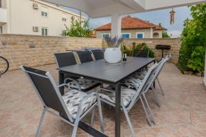 ein schwarzer Tisch und Stühle auf einer Terrasse in der Unterkunft Family friendly house with a parking space Zaton, Zadar - 23570 in Zaton
