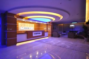 Un vestíbulo con una zona de espera con un cartel en la pared. en Bupa Hotel, en Kayseri