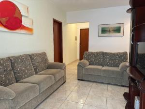 ein Wohnzimmer mit zwei Sofas und einer Couch in der Unterkunft Apto Próx. ao Mar na Guilhermina - Melhor Local in Praia Grande