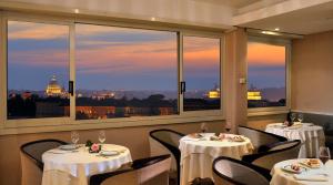 ローマにあるベスト ウエスタン ホテル ピカディリーの市街の景色を望むレストランで、テーブル2台が備わります。