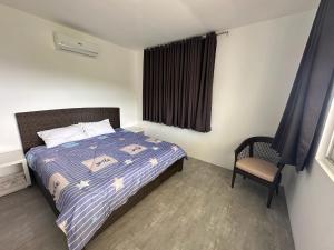 a small bedroom with a bed and a chair at Assaly Villa - Breathtaking Ocean View with private beach in San Jose +37 photos