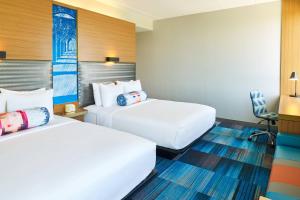 サンアントニオにあるAloft San Antonio Airportのベッド2台と椅子があるホテルの部屋 +7枚の写真