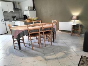 un tavolo da pranzo con sedie e una cucina di Gîte familial à la ferme avec jardin clos, proche Forêt d'Orléans et étangs, lits faits, jeux enfants - FR-1-590-88 a Vieilles-Maisons-sur-Joudry
