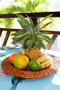 a basket of fruit on a table with a pineapple at Appartement Manganao beach in Saint-François