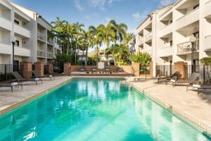 a swimming pool in front of a building at Courtyard by Marriott West Palm Beach in West Palm Beach