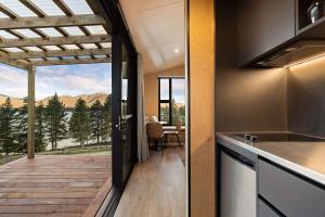 a kitchen and dining room with a view of a deck at The Huts at Lakes Edge in Lake Tekapo