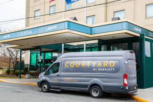 a van parked in front of a court yard by marriott building at Courtyard by Marriott New York JFK Airport in South Ozone Park