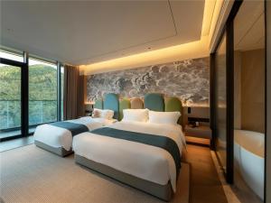 Postel nebo postele na pokoji v ubytování Yibo Jinling Hotel Moganshan