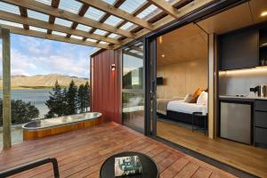 a room with a view of a bed and a kitchen at The Huts at Lakes Edge in Lake Tekapo