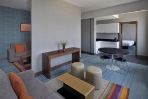 a living room with a couch and a table at Aloft Dhahran Hotel in Al Khobar +39 photos