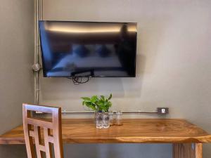 チェンマイにあるLanna Treeの木製テーブルの上に掛けられたテレビの上 +10枚の写真