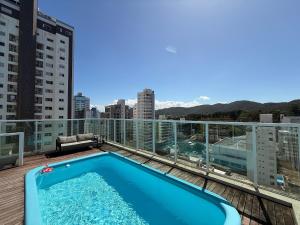 a swimming pool on the roof of a building at QE01- Studio| Jacuzzi Aquecida| Piscina| Churrasq. in Cabeçudas
