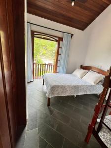 a bedroom with a bed and a door to a porch at Pousada Recanto do Patrimônio in Paraty +23 photos