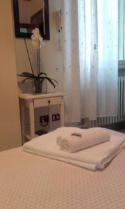 a bedroom with a bed with a table and a window at Albergo Trattoria Fioravante in Peschiera del Garda