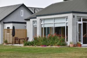 a house with a garden with flowers in front of it at 74 on Lockhart in Oturehua +28 photos