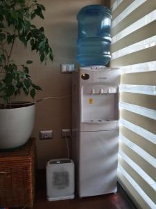 a small refrigerator with a water jug on top of it at Departamento con AC Ñuñoa in Santiago