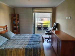 a bedroom with a bed and a dresser and a desk at Departamento con AC Ñuñoa in Santiago +26 photos