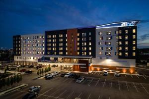 a large building with cars parked in a parking lot at Aloft Columbus in Columbus