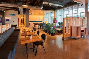 - un restaurant avec des tables et des chaises en bois dans une chambre dans l'établissement Aloft Cleveland Airport, à North Olmsted