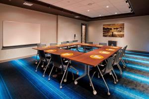 une salle de conférence avec une grande table et des chaises en bois dans l'établissement Aloft Cleveland Airport, à North Olmsted 24 autres photos