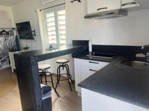 a kitchen with a black counter top and a sink at Over The Hill Residence - Your Tranquil Oasis in Grand Case +63 photos
