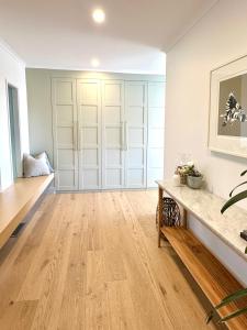 a living room with wooden floors and white walls at Coastal Family Haven with Pool - Mornington Peninsula in Frankston South