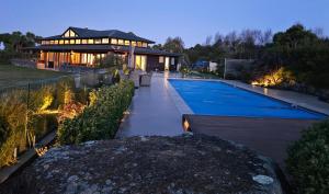 a house with a swimming pool in front of a building at Kākahu Lodge in Geraldine