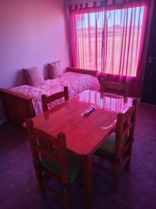 Habitación con mesa, cama, mesa y sillas. en Cabañas Emilia, en La Adela