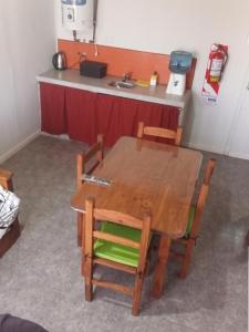 a table and chairs in a room with a kitchen at Cabañas Emilia in La Adela