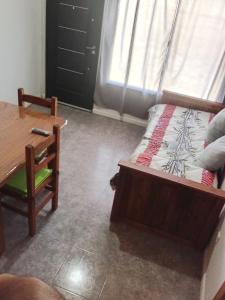 Un dormitorio con una cama, una mesa y un escritorio. en Cabañas Emilia, en La Adela