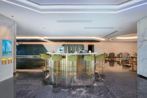 un bar en una habitación con taburetes verdes en Guangzhou Meihua Hotel, en Huadu