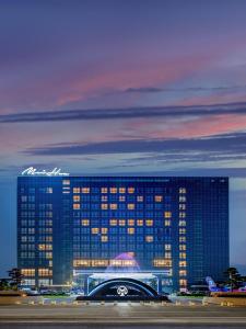 un edificio iluminado por la noche con acedes en Guangzhou Meihua Hotel, en Huadu