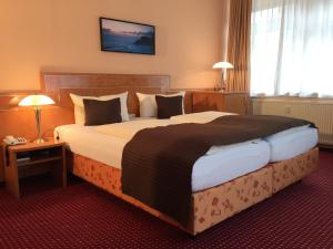 a bedroom with a large bed in a hotel room at Wincent Hotel in Sinsheim