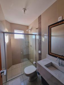 a bathroom with a shower and a toilet and a sink at Apartamento Barra Velha Praia do Tabuleiro in Barra Velha