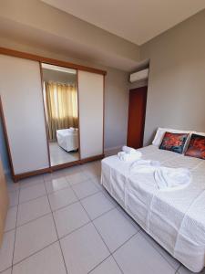 a bedroom with a bed and two large mirrors at Apartamento Barra Velha Praia do Tabuleiro in Barra Velha
