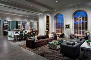 a living room with couches and a kitchen and a bar at AC Hotel by Marriott Spartanburg in Spartanburg