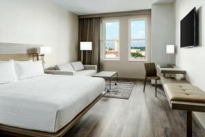 a hotel room with a bed and a desk and window at AC Hotel by Marriott Spartanburg in Spartanburg