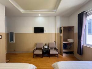 a room with two chairs and a table and a tv at Guest house Hai Cô Chú in Da Lat
