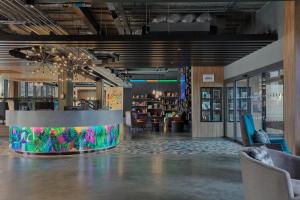 a lobby with a table and chairs in a room at Aloft Aberdeen TECA in Aberdeen
