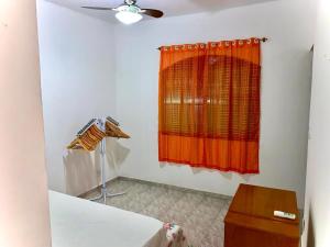 Una habitación con una cortina naranja y una ventana. en Casa Grande Com Churrasqueira E Garagem, en São Pedro da Aldeia 5 fotos más