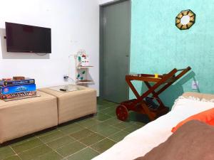 a bedroom with a bed and a flat screen tv at Casa Grande Com Churrasqueira E Garagem in São Pedro da Aldeia