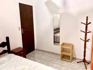 a bedroom with a bed and a mirror on the wall at Casa Grande Com Churrasqueira E Garagem in São Pedro da Aldeia