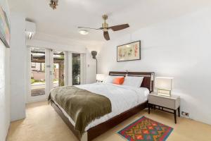 a bedroom with a bed and a ceiling fan at The Cornerstone - A Stylish Garden Terrace in Sydney