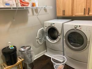 - une buanderie avec un lave-linge et une poubelle dans l'établissement Chateau Sean, à Braselton