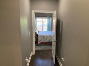 - un couloir avec une chambre dotée d'un lit et d'une fenêtre dans l'établissement Chateau Sean, à Braselton