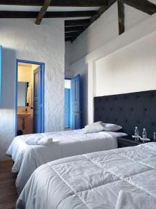 two beds in a bedroom with blue walls at Patio Chic in Jericó +48 photos